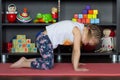 Little girl making yoga cat pose indoor