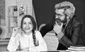 Little girl and man against blackboard. Consulting student. Homeschooling project. Knowledge day. Child with teacher in Royalty Free Stock Photo