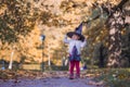 Little girl masquerade as a witch with halloween hat in sunny yellow fallen park Royalty Free Stock Photo