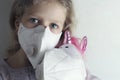 Little girl in a medical mask hugs a unicorn