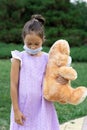 A little girl in a medical mask is waiting for the end of the quarantine and misses a normal life
