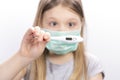Little girl in a medical mask on a white background. Coronovirus concept
