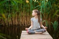 Little Girl meditating at sunrise on the beach Royalty Free Stock Photo