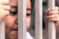 Little girl with metal fence, feeling no freedom.