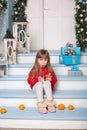 Little girl with milk and a gingerbread man sitting on porch near house. child eats cookies with milk on porch at home. Child with Royalty Free Stock Photo