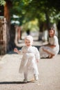 Little girl with mom in a beautiful white dress, smiles and runs in a green park, picnic Royalty Free Stock Photo