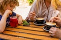 the little girl with mom and grandma drinks juice in a cafe Royalty Free Stock Photo