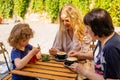 the little girl with mom and grandma drinks juice in a cafe Royalty Free Stock Photo