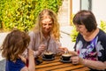 the little girl with mom and grandma drinks juice in a cafe Royalty Free Stock Photo