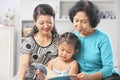 Little girl with mom and grandma reading book Royalty Free Stock Photo