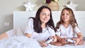 Little girl and mom are playing a computer game with mom. Jostics in hand. Modern computer games for children and