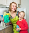 Little girl and mom tidy up at kitchen Royalty Free Stock Photo