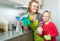 Little girl and mom tidy up at kitchen Royalty Free Stock Photo