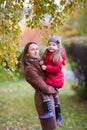 Little girl and mother in the autumn park