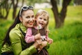 The little girl with mother blows a dandelion