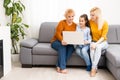 little girl mother and grandmother with laptop while sitting on sofa at home Royalty Free Stock Photo