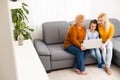 little girl mother and grandmother with laptop while sitting on sofa at home Royalty Free Stock Photo
