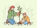 Little girl and mother plant tree in park, helping restore nature that has suffered from forest fire Royalty Free Stock Photo