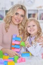 Little girl and mother playing with colorful plastic blocks at h Royalty Free Stock Photo