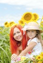 Little girl and mother with sunflowers in a summer day. Royalty Free Stock Photo