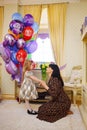 little girl and mum at home with balloons. Inflatable hero of Russian cartoon