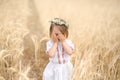 A little girl in a national Belarusian shirt covers her face with her hands Royalty Free Stock Photo