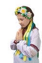 A little girl in national Ukrainian clothes with tearful eyes folded her hands in front of her and prays for an end to the war in