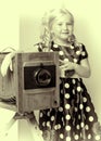 Little girl near a big retro camera. Royalty Free Stock Photo