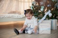 Little girl near Christmas tree with presents rejoices holiday, new year, decorations, gift, box, holiday, lifestyle Royalty Free Stock Photo