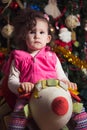 Little girl near Christmas tree waiting for Christmas