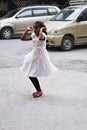 A little girl from Nepal in a white festive dress dancing on the street on the Diwali or Deepavali holiday