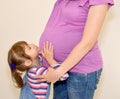 The little girl nestles on a stomach of pregnant mother Royalty Free Stock Photo