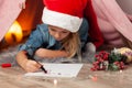 A little girl on New Years Eve writes a letter to Santa Claus. Christmas wishes, home holiday Royalty Free Stock Photo