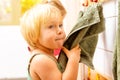 Little girl in nursery school using towel in bathroom Royalty Free Stock Photo