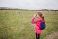 Little girl observing with binoculars nature landscape on spring day Royalty Free Stock Photo