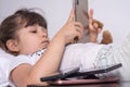 Little girl obsessed with phones mobile apps ignoring parents and toys at home, kid using smartphones checking social networks onl Royalty Free Stock Photo