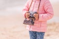 Little girl with old vintage camera making photos of sea waves and beach. Young photographer Royalty Free Stock Photo
