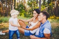 Little girl one year on the background of parents resting lying on grass learning to walk on nature in the park. The first steps o Royalty Free Stock Photo