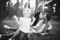 Little girl one year on the background of parents resting lying on grass learning to walk on nature in the park. The first steps o Royalty Free Stock Photo