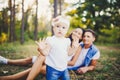 Little girl one year on the background of parents resting lying on grass learning to walk on nature in the park. The first steps Royalty Free Stock Photo