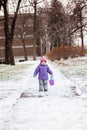 Little girl one year old playing with snow outside in winter park. Royalty Free Stock Photo