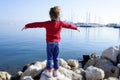 Little girl open arms looking marina blue sea Royalty Free Stock Photo