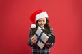 Little girl open present box. happy new year gift. time for christmas holiday presents. small girl in santa hat Royalty Free Stock Photo