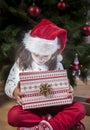 Little girl opening he present under Christmas tree Royalty Free Stock Photo