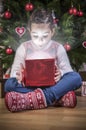 Little girl opening he present under Christmas tree Royalty Free Stock Photo