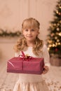 A little girl opens a Christmas present from Santa. Christmas tale. Happy childhood Royalty Free Stock Photo
