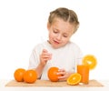 Little girl with oranges drink juice with a straw Royalty Free Stock Photo