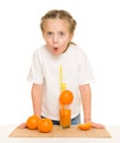 Little girl with oranges drink juice with a straw Royalty Free Stock Photo