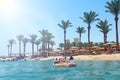 Little girl and others tourists relaxing on tropical beach during holidays Royalty Free Stock Photo