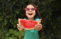 Cute little girl outdoors, focus on hands with watermelon